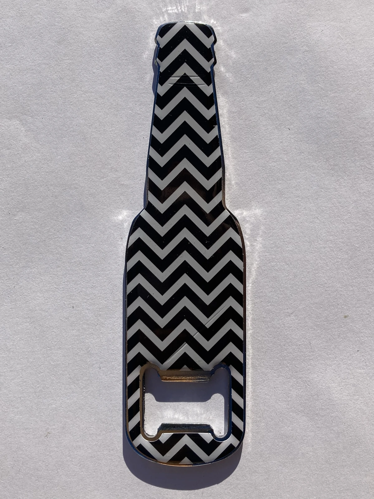 Beer bottle shaped metal bottle opener with blackandwhite zigzag