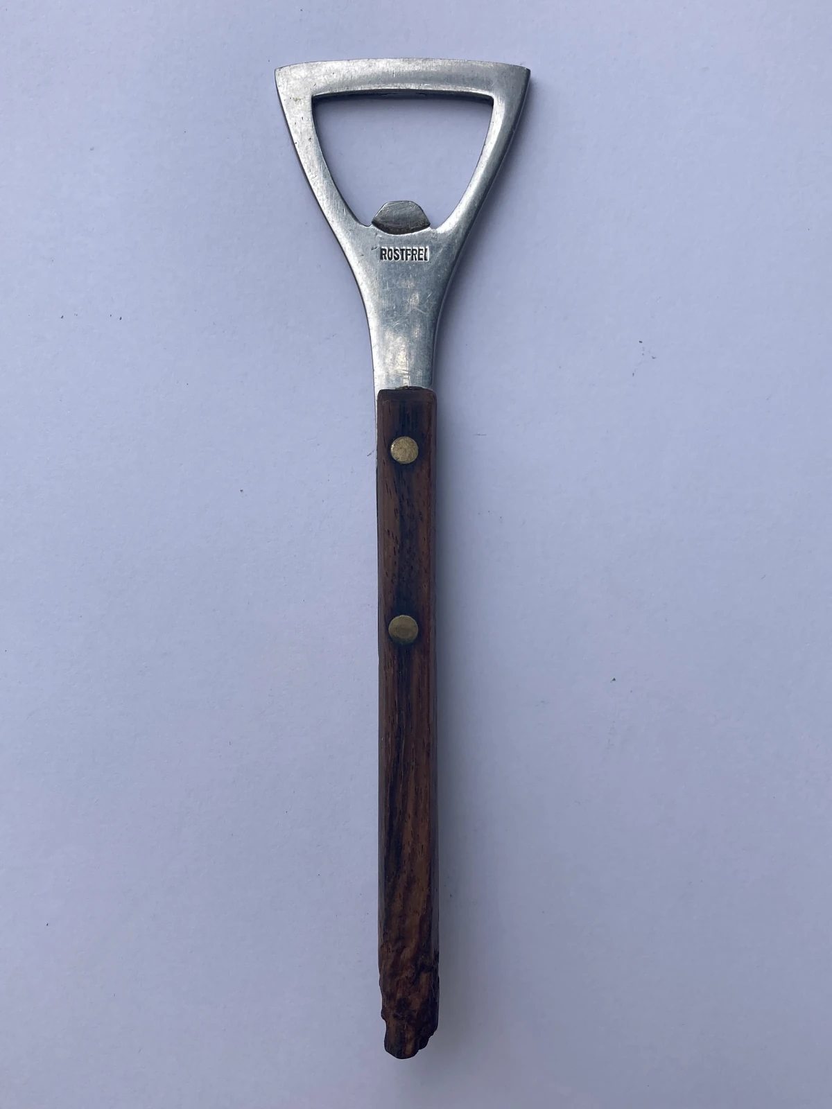 Bottle opener with dark colored long and thin wooden handle (Rostfrei