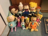 Rosie's and his plush toy gang. Left to right: Fracture Fairy Tales (foreground); Rosie O' Donnell (head seen only); Granny Puppet; Dino; Tommy Puppet; George Jetson (foreground); Barney Rubble (foreground); Katie Puppet; Talking Fred Flintstone (foreground); Talking Norman (behind Cindy); Cindy Vortex