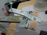 "And here you can see the new tilt mechanism. The Manfraudo Arc has been transformed again, with the addition of an arm through which a long screw has been tapped. This allowed us to wind the camera up and down with ease, and with as fine an adjustment as needed. The upwards-facing screw poking through the perspex on the right attaches to the standard tripod mount in the bottom of the camera. A wire pointer was Blu-Tacked onto the top of the screw to indicate what direction it was facing and we just kept a track of how many turns were on it at all times."