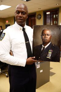 Andre Braugher in costume posing with his character's portrait