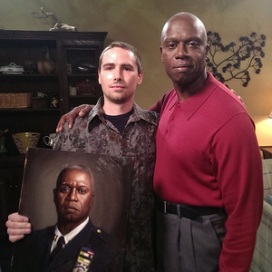 The artist, Eric Skotnes with the painting of Raymond Holt and the actor Andre Braugher