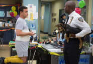 Captain Holt talking to Boyle while holding the puppies