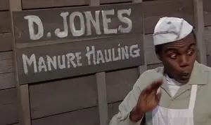 Goldie Wilson junto al letrero de D. Jones en 1955.