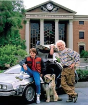 Michael J. Fox y Christopher Lloyd posan junto a Freddie para una foto publicitaria en 1989 como Marty McFly, Doc Brown y Einstein en el set de la plaza de la Corte de 2015.