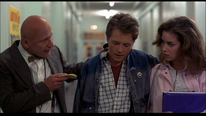 Mr. Strickland holds his tardy slip pad between his index and middle fingers as he gives Marty "a nickel's worth of free advice", while Jennifer looks on.