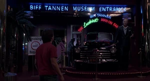 A waxwork figure of Biff Tannen (on the far right), posing with his newly restored 1955 Ford Super De Luxe Convertible at the entrance of the Biff Tannen Museum in 1985A.