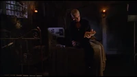 Spike reading a book in his crypt.