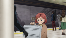 Aya receiving a suitcase from an unknown man