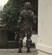 A soldier holding an AK-47 with a folded Duster Stock