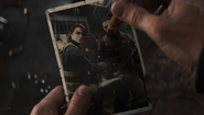 Ravenov burning his photograph with a cigarette.