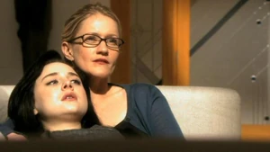 Amanda and Zoe watch Daniel on a television interview with Baxter Sarno.