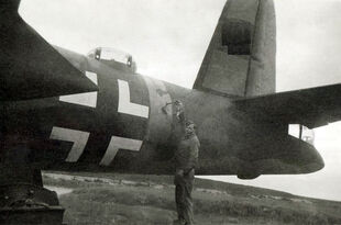 An RAF ground crew inspects 41-17790, which has the Nazi markings it wore for nearly two and a half years. The bright yellow fuselage band and tail flashes can still be seen (though barely visible on orthographic film), but the swastika has been blanked out by a censor in this photo. We can also see the paint circle where the old USAAF star roundel was painted over–just to the right of the airman.