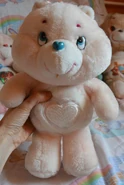 White heart on a pale pink bear with a blue nose