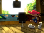 Numbuh 5 pushes a swiveling chair with the Cartoon Network logo on it.