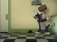 Tom waits outside of Jerry's hole with a mallet in his hands.