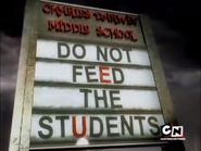 On a rainy morning, the school billboard reads "Do not feed the students".