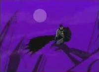 Batman is seen perched over a statue in the night sky.