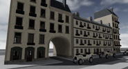 Development screenshot of a hotel with cars in front.