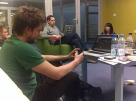 Artur (Android Dev), Grzegorz (iOS Dev), Federico (Lead Dev), and Deb (Designer) discussing user interface challenges in the Poznan office