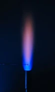 Flame test on sodium carbonate seen through cobalt glass