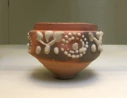 A cup, 6.5 cm. high, made at Aswan, Egypt, in the 1st-2nd C AD, and decorated with barbotine patterns.
