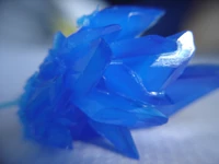Cristal de sulfato de cobre. Se aprecia que el cristal no crece uniformemente sino que existen planos que han crecido con mayor rapidez.
