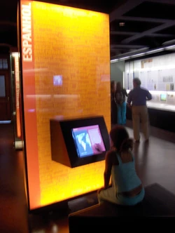 Fotografía que muestra la interactividad del espacio, en la que se observa como se divierten los visitantes interactuando con los tótems y aprendiendo sobre las influencias de otras lenguas en el origen de las palabras portuguesas.