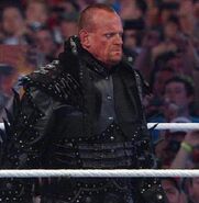 The Undertaker showing his short mohawk to Triple H before the match begins, after he cuts his hair off to no longer have long hair.