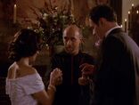 The Dark Priest helps place the rings on Cole and Phoebe's fingers.