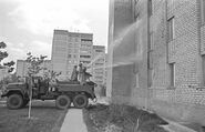 Ликвидаторы спрей зданий в Припять с рукавов высокого давления для удаления радиоактивной пыли.