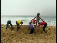 The Wiggles, Santa Claus and Henry building a sandcastle