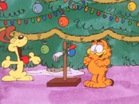 Odie presents Garfield with the back-scratcher.