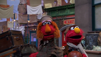 Elmo's great-grandmonster arrives with his dad.