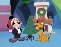 Mickey and Pluto with a small Christmas tree.