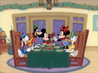 Mickey and his friends sitting down to Christmas dinner in "Mickey's Mixed Nuts".