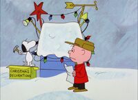 Snoopy decorating his doghouse