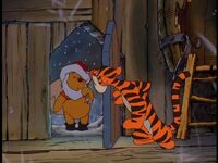 Pooh, disguised as Santa, arrives at Tigger's house.