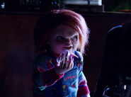 Alice's Chucky offering Nica a shard of glass to kill Dr. Foley in Cult of Chucky.