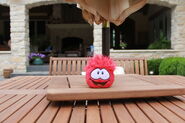 A red puffle plush sitting on a table