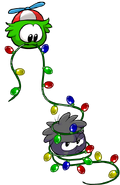 A green puffle along with the Black Puffle playing with lights.