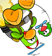 As seen on the green version of the "Puffles!" login screen, along with the Red Propeller Cap