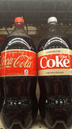 The 2018 2 Liter Contour Bottle design of Caffeine Free Coca-Cola shown on the right next to the Caffeine-Free Diet Coke variant.