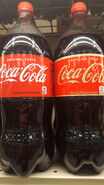 The 2019 2 Liter Countour Bottle design of Coca-Cola shown on the right next to the 2018 Caffeine-Free variant.