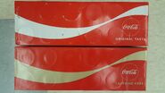 A 2017/2019 12 Can Pack Design of Coca-Cola next to the 2018 Caffeine Free Variant
