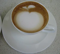 A cappuccino with an apple drawn with the foam