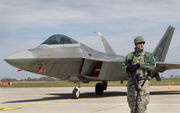 Military Policeman guards an F-22 Raptor Jet, Cascadia's standard fighter jet.