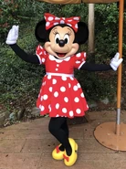 Minnie Mouse wearing a red dress with white spots
