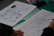 The editor compares the neemu (a manga "rough draft") (right) with the finished page (left) for changes or errors.