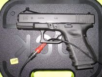 A Glock 19 in a case with a wire.